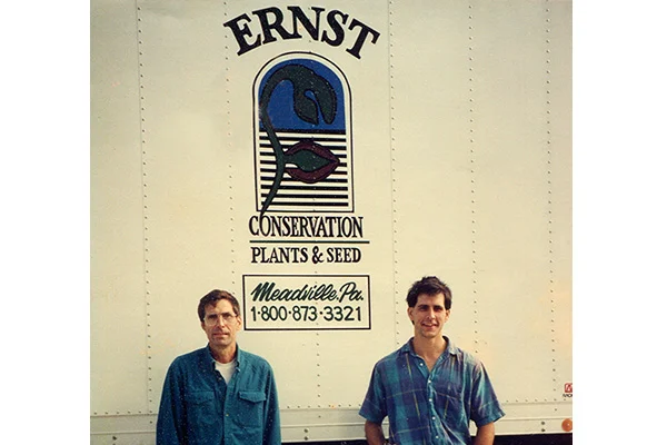 Founders posing in front of their company truck with their logo