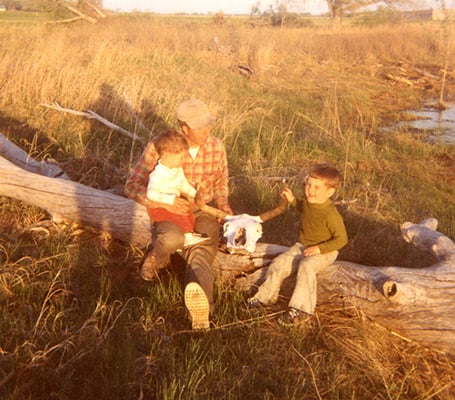 Ernst family sitting on a dead tree in a field